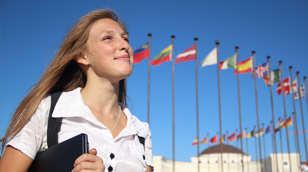 Female with international flags on flag poles in background